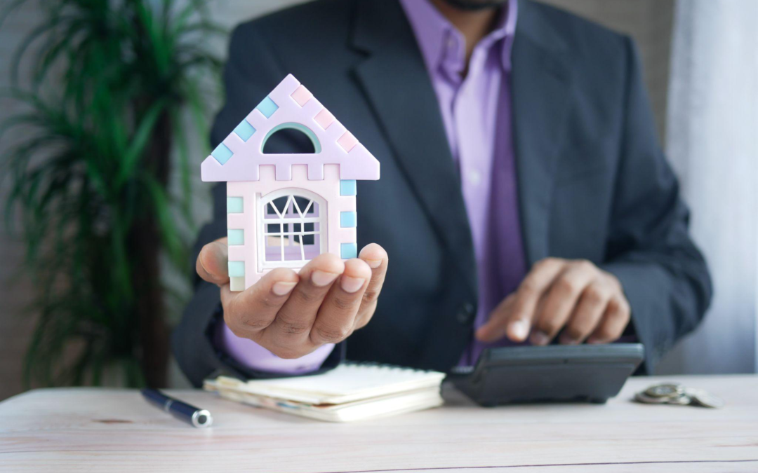 A man holding a house in hand.